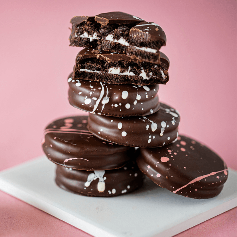 Chocolate covered cookies on pink background.