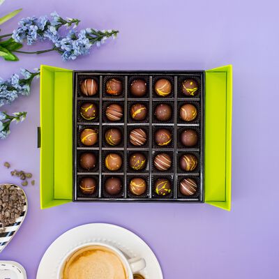 Chocolate truffle gift box on purple background. 