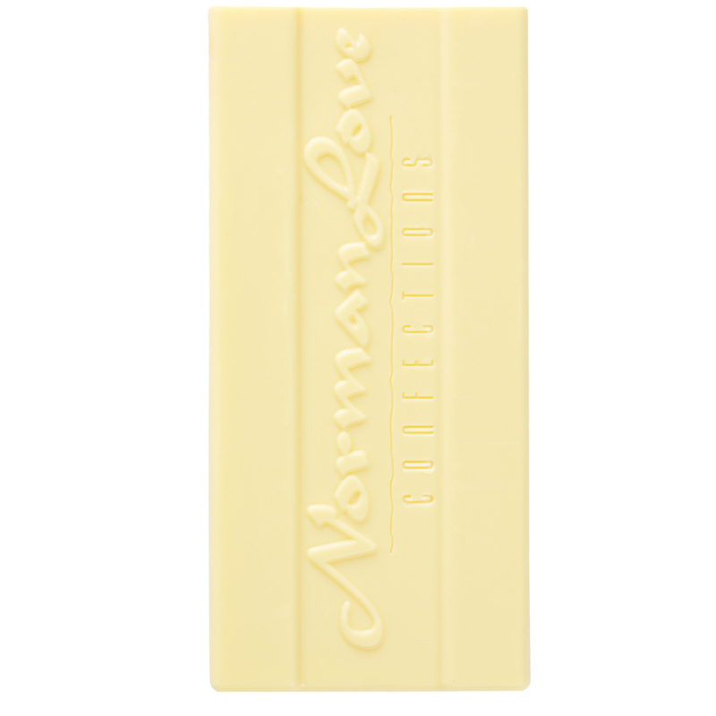 Unwrapped Vegan White Chocolate Bar on white background. Rectangle bar has "Norman Love Confections" printed on it. 