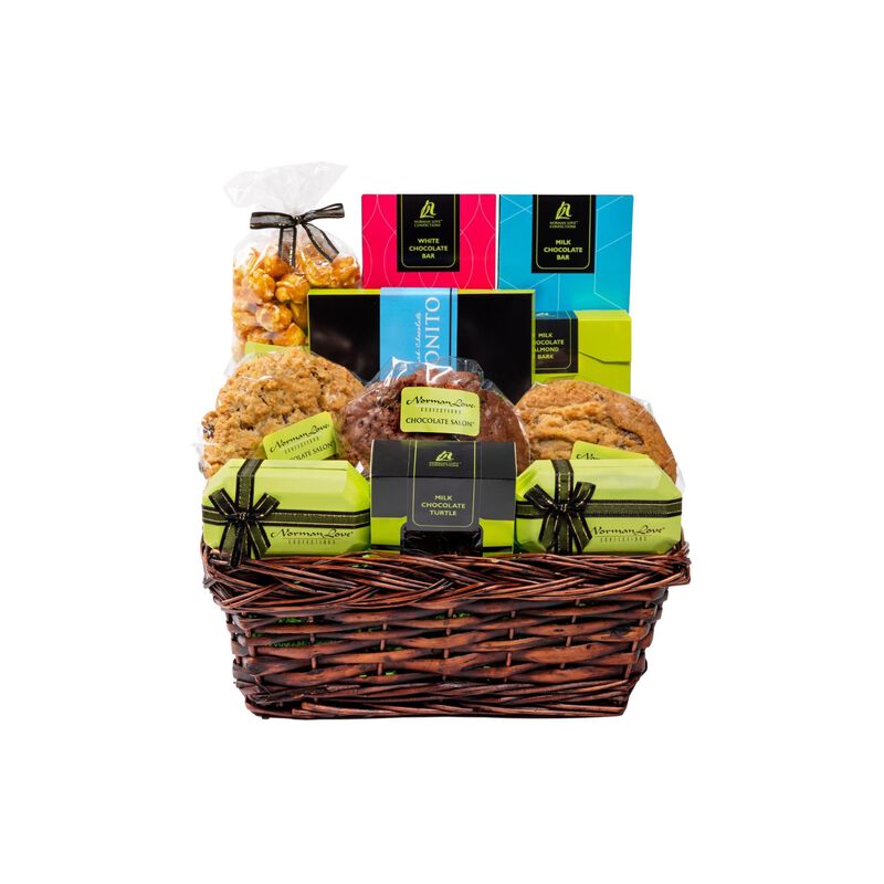 Brown gift basket on white background. Gift basket contains green boxes with black bows, cookies, caramel corn, and pink and blue wrapped chocolate bars.