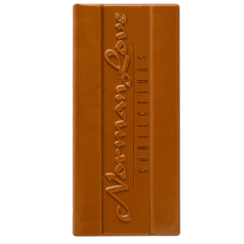 Unwrapped Vegan Milk Chocolate Bar on white background. Rectangle bar has "Norman Love Confections" printed on it. 
