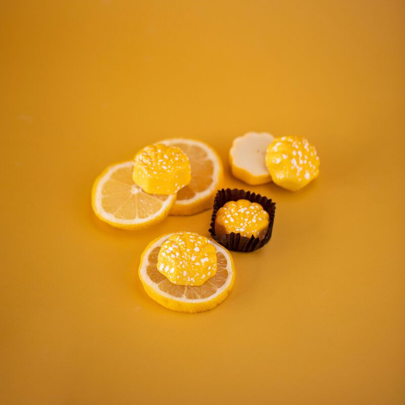Lemon truffles on orange background.