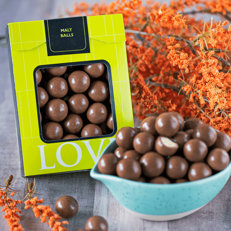 Milk chocolate malt balls in blue bowl.