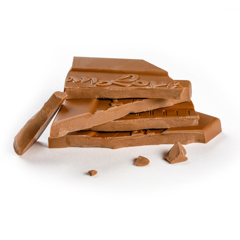 Stacked, broken pieces of Vegan Milk Chocolate Bar on white background.