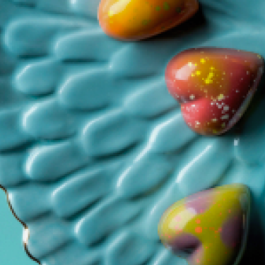 Heart-shaped truffles on a blue plate. 