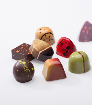 Multi-colored truffles on white background. Truffles are various shapes and sizes. 