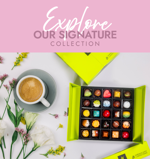Chocolates on a dusty pink background. Text explore our signature collection