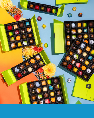 An array of open chocolate gift boxes, showing a variety of chocolates in different shapes, colors and flavors.